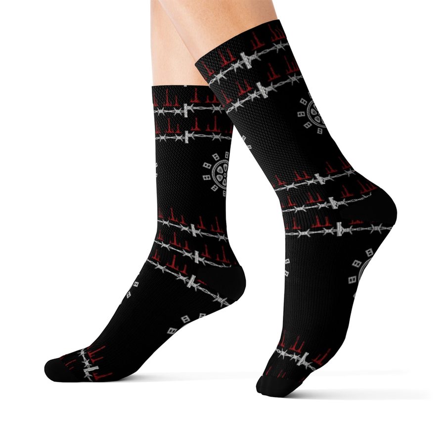 Reel Crypt Crew Socks, worn side view: black socks with white barbed wire bands dripping red and film reel emblems