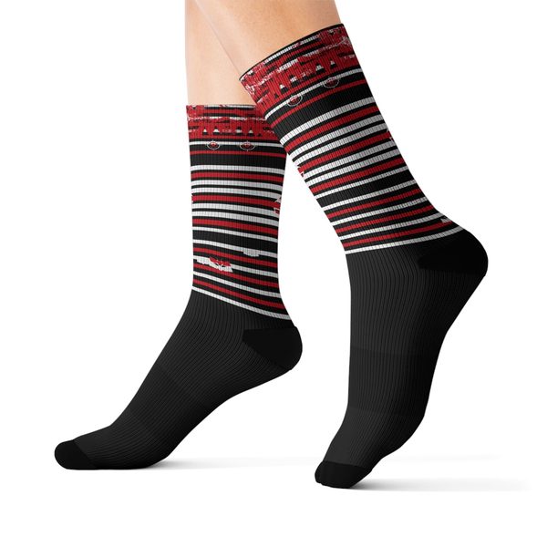 Static Moth Crew Socks, worn side view: black socks with red and white stripe bands and a winged moth emblem